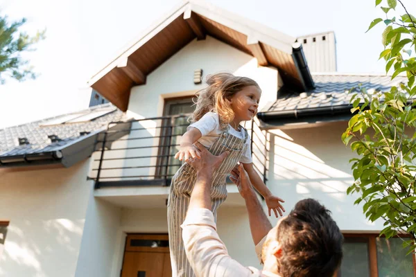 Mutlu bir baba kızını havaya kaldırıyor, yeni bir ev almayı kutluyor, bahçelerinde güneşli bir günün tadını çıkarıyor, aileyi, mutluluğu ve Amerikan rüyasını simgeliyor.