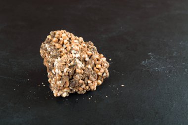 Sütlü çikolata ile şişirilmiş pirinç ve kuru üzüm siyah arka plan üzerinde tek parça