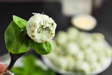 İtalyan ıspanak gnocchi çatal üzerinde arka plan üzerinde büyük plaka ile kapalı ısırıldı