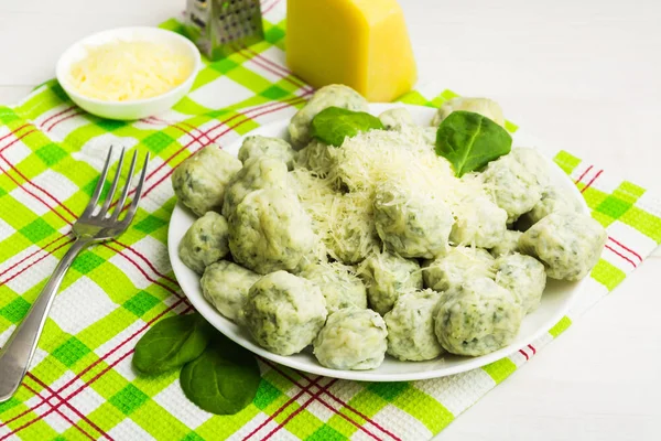 Beyaz zemin üzerine peynir ile ıspanak gnocchi yeşil dokular ile büyük tabak