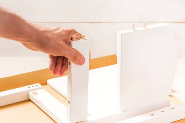 Adam elini beyaz arka plan üzerinde bir mobilya parçası tutuyor