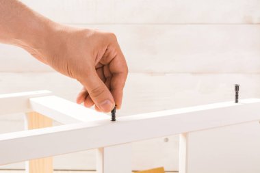 Erkek el çocuk sandalye beyaz arka plan üzerinde uyan ve vida tutar