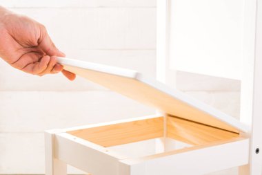 Adam küçük çocukların sandalye beyaz arka plan üzerinde koltuk koyar