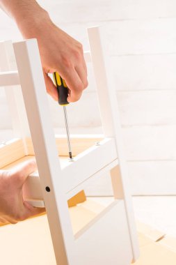 Erkek el bir tornavida tutan ve kopya alanı ile beyaz arka plan üzerinde beyaz mobilya bir vida twist