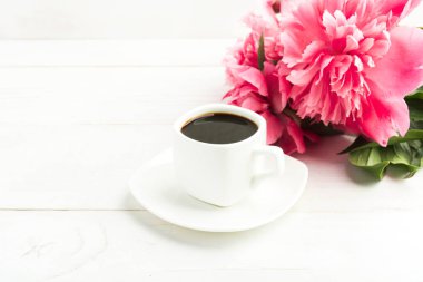 Bir fincan kahve ile kopya alanı ile beyaz tahta masaya pembe peony çiçek