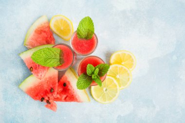 Yaz taze sağlıklı içecek karpuz, limon ve nane kopya alanı, düz ile mavi arka plan üzerinde yatıyordu
