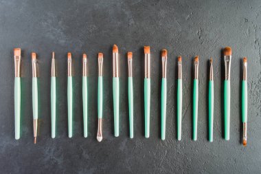 Fırçalar siyah arka plan, düz yatıyordu stil üzerinde yeşil mil ile profesyonel kozmetik set