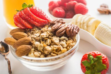 Sabah ev yapımı granola ile fındık ve çilek, banan ve arka plan üzerinde suyu