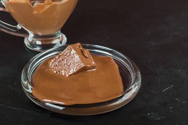 Молочный Расплавленный Шоколад Тарелке Стеклянной Банкой Черном Бэкгрунде — стоковое фото