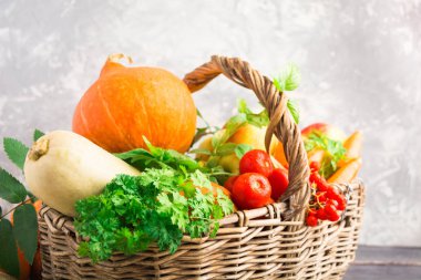 Hasır sepet sonbahar meyve ve sebzeler üzerinde gri arka plan, seçici odak ile