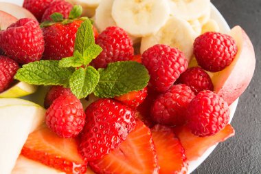 Plaka üzerinde closeup görünümü taze çilek, muz, elma ve nane yaprakları