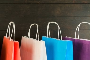 Kopya alanı ile ahşap arka plan üzerinde renkli kağıt torbalar. Alışveriş Satış konsepti