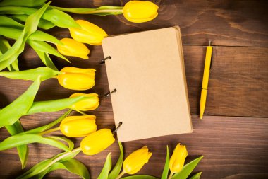 Açık kitap kopya alanı, düz ile tatil için sarı kalem ile sarı laleler ile yatıyordu