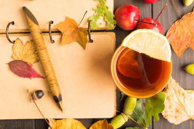 Ahşap masa planı ve limonlu sıcak içecek için açık kitapları ile sonbahar konsepti