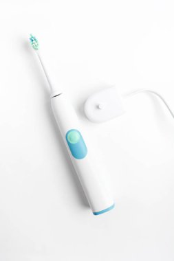 Beyaz arka plan, üstten görünüm, düz yatıyordu stil, akü şarj cihazı ile elektrikli diş fırçası dikey vurdu