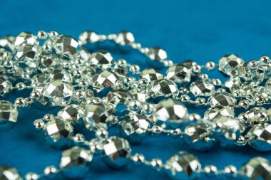 Seçici odak ile mavi arka plan üzerinde gümüş Noel çelenk