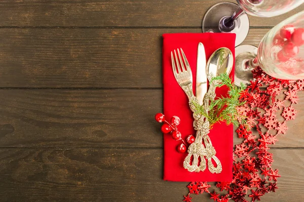 Table setting for winter holiday on wooden background with copy space, flat lay style