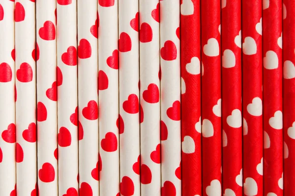 Red and white ecological plastic free paper straw with hearts, flat lay