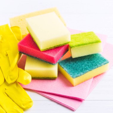 Sünger, bez ve eldiven Beyaz ahşap arka planda, kare ile sıhhi ev ödevi için farklı aksesuarlar vurdu