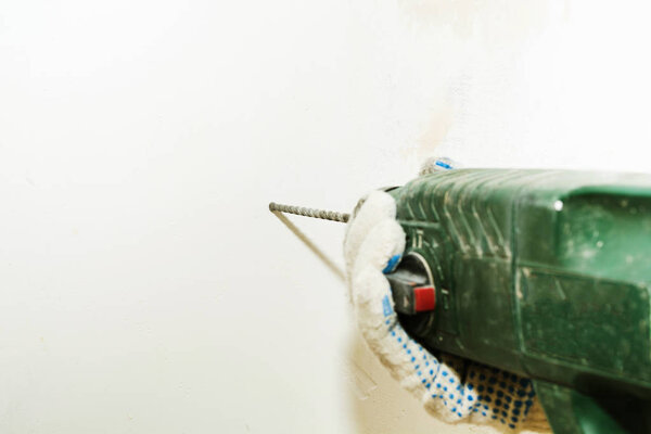 Dirty perforator in male hands with focus on drill with copy space