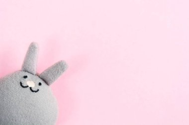 Komik oyuncak gri tavşan (tavşan) pembe kağıt arka plan kopya alanı, düz ile üzerinde yatıyordu