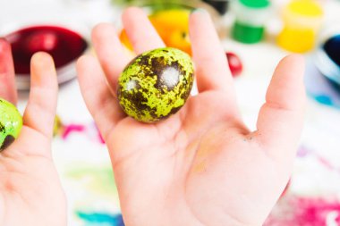 Çocuğun elinde, seçici odak renkli Paskalya yortusu yumurta