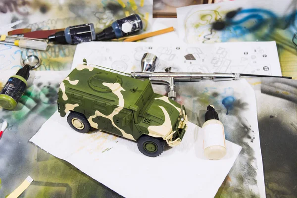 Russian military armored camouflage jeep Tiger. Plastic scale model on working space