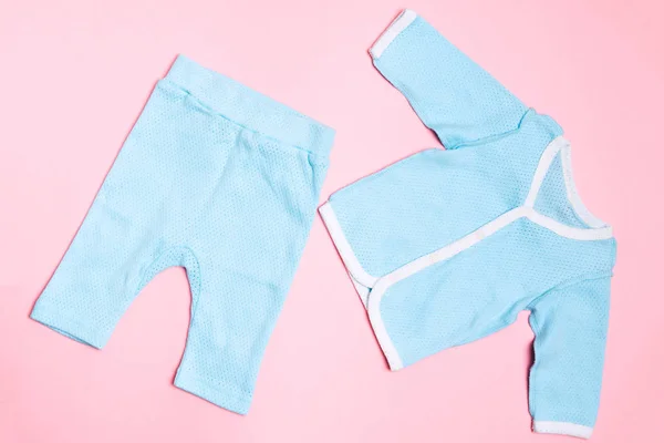 Blauwe baby kleding op roze achtergrond met overhemd en broek. Kind design zomer mode — Stockfoto