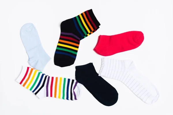 Verschiedene farbenfrohe Textilsocken auf weißem Hintergrund. Beinkleidung. Casual Style. Ansicht von oben — Stockfoto