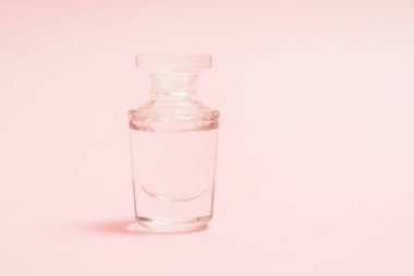 Pembe arka planda parfüm şeffaf şişe. Mock. Yakın çekim görünümü. Aroma kozmetik