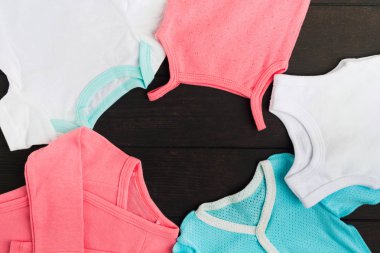 Ahşap masa üzerinde Modern pamuk bebek giysileri. Babysuits çerçeve. Kopya alanı. Düz yatıyordu