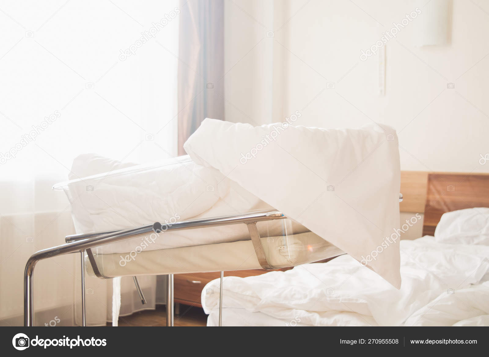 Cot For Newborn Baby With White Coverlet In A Hospital Room