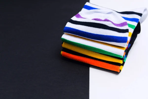Набір барвистих смугастих білих і чорних шкарпеток на білому і чорному тлі з копіювальним простором — стокове фото