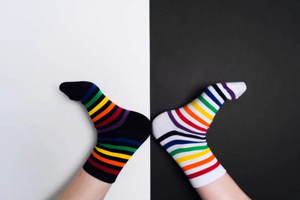 Funny legs with white and black striped new clean colorful textile socks. Fashion accessories for feet with negative background with copy space