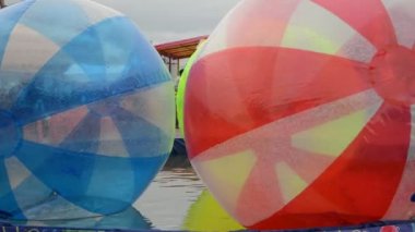 Su havuzunda iki mavi ve kırmızı büyük su balonu aquazorb