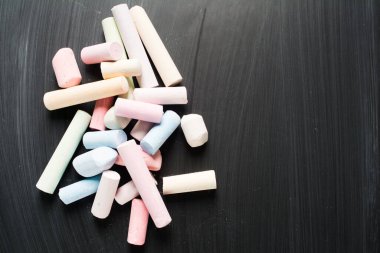 Tahtanın üzerinde renkli pastel tebeşir parçaları var.