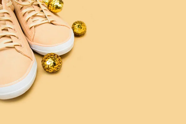 Creative Christmas shoe shop background with beige sneakers and gold decoration