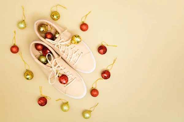 Kerst schoen winkel achtergrond met beige sneakers en rood en goud decoraties — Stockfoto