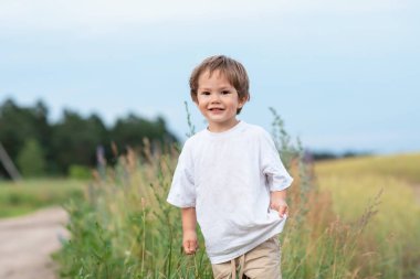 Küçük çocuk çimlerin arasından geçiyor.