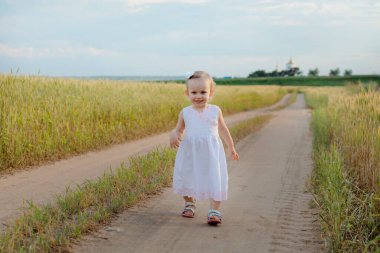 Küçük kız çimlerin arasında yolunu buluyor.