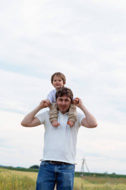 Baba ve küçük oğlu tarlada yürüyor.