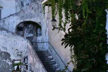 Duvarda bir fener ve taş merdivenlerde