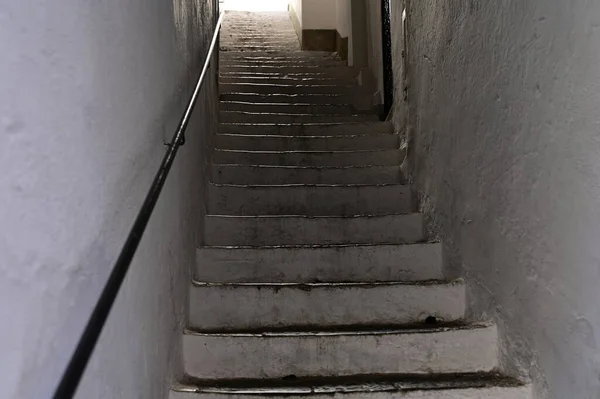 İki beyaz duvar arasındaki taş merdivenler.
