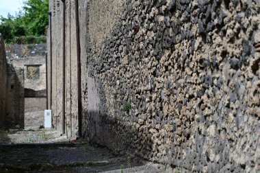 Renkli taşlardan bir duvar ve gri bir yol.