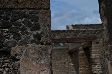 Arkasında harabeler olan renkli taş bir duvar.