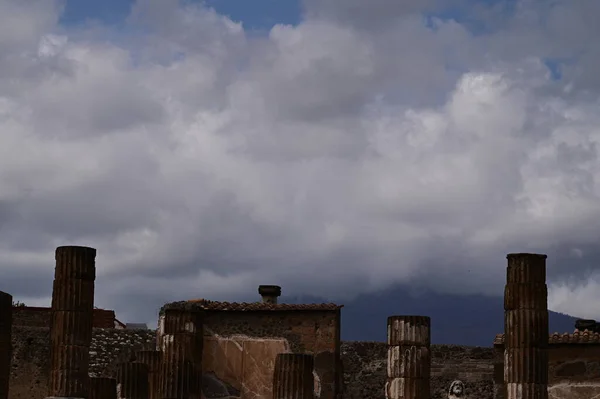 White clouds and blue sky above ancient columns