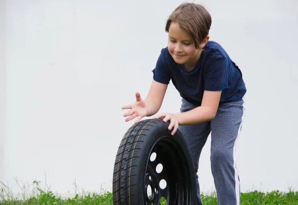 Niño Sonriente Rodando Una Rueda Coche Fondo Blanco — Foto de Stock