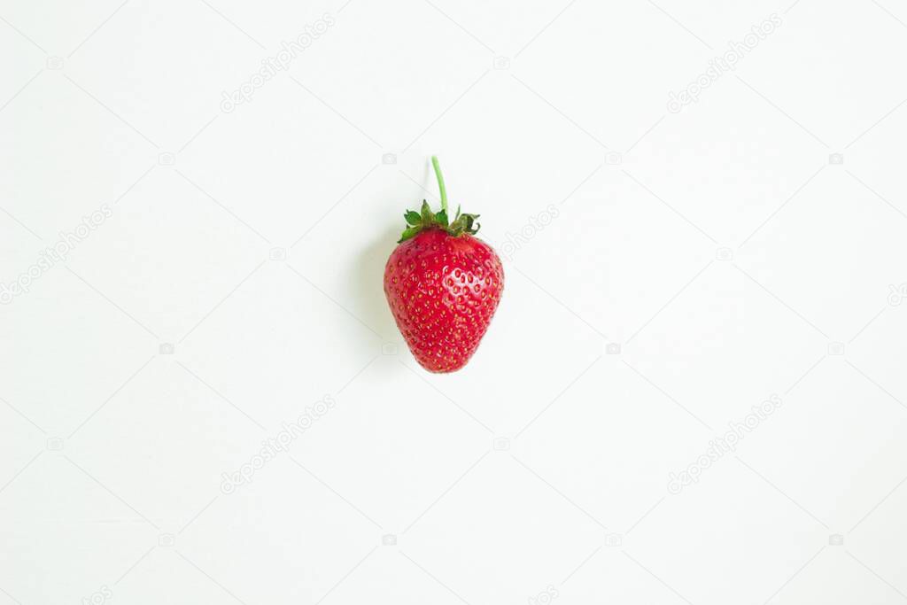 One ripe red strawberry on a white background