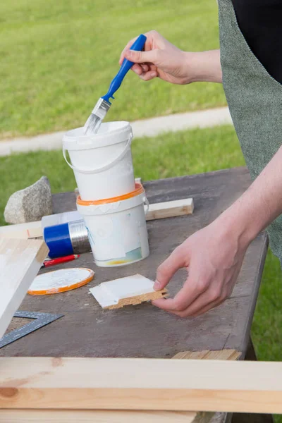 Giovane Designer Dipinge Una Tavola Legno Bianca Con Una Spazzola — Foto Stock