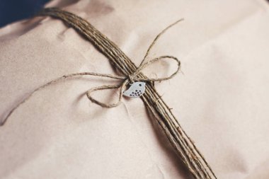 Kenevir kordonu ile Zanaat kahverengi kağıt paketi. Parsel sarma. Metal kuş kolye ile.